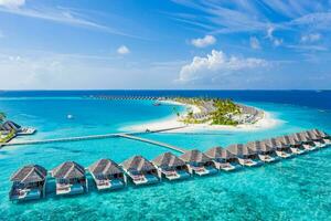 Maldives paradise island. Tropical aerial landscape, seascape long jetty pier water villas with amazing sea and lagoon beach, tropical nature. Exotic tourism destination. Best summer vacation photo