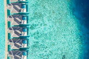 Maldives paradise island. Tropical aerial landscape, seascape long jetty pier water villas with amazing sea and lagoon beach, tropical nature. Exotic tourism destination. Best summer vacation photo