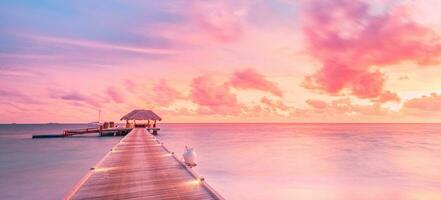 Beautiful sunset beach scene. Colorful sky and clouds view with calm sea and relaxing tropical mood. Beautiful sunset landscape, luxury resort and colorful sky. Artistic beach sunset, wonderful sky photo