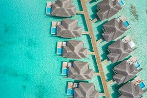 Maldives paradise lagoon bay. Tropical aerial landscape, seascape long pier bridge water villas with amazing sea coastline beach, tropical nature. Exotic tourism destination. Best summer vacation photo