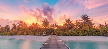 Amazing beach landscape. Beautiful Maldives sunset seascape view. Horizon colorful sunset sea sky clouds over pier pathway lights. Tranquil island lagoon, tourism travel background. Exotic vacation photo