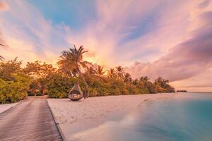 Amazing beach landscape. Beautiful Maldives sunset seascape view. Horizon colorful sunset sea sky clouds over pier pathway lights. Tranquil island lagoon, tourism travel background. Exotic vacation photo