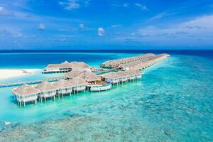Maldives paradise island. Tropical aerial landscape, seascape long jetty pier water villas with amazing sea and lagoon beach, tropical nature. Exotic tourism destination. Best summer vacation photo