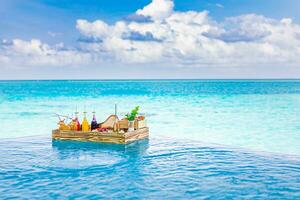Breakfast in swimming pool, floating breakfast in tropical resort. Table relaxing in calm pool water, healthy breakfast and fruit plate by resort pool. Exotic summer diet luxury island beach lifestyle photo