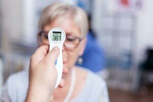 Reading body temperature using infrared thermometer during medical examination. Consultation for infections and disease during global pandemic, flu, tool, sickness. photo
