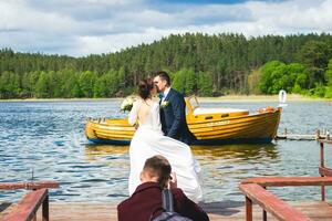 Young caucasian Lithuanian couple on bridge pose for photographer with lake panorama photo