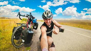 Male person takes a selfie on bicycle vacation in scenic caucasus mountain region. Travel bicycle touring concept. photo