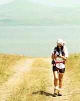 Woman use phone navigation outdoors to navigate on hiking trail to reach destination in caucasus mountains photo