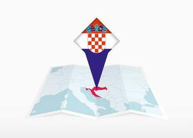 Croacia es representado en un doblada papel mapa y clavado ubicación marcador con bandera de Croacia. vector