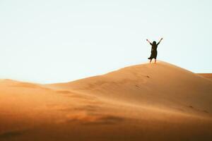 Solo woman stand on top dune enjoy panorama and sunset in Kashan desert in Iran photo