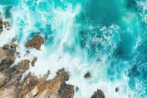 ai generado parte superior ver de azul Oceano olas estrellarse en rocoso línea costera, aéreo zumbido disparo, aéreo ver de mar y rocas, Oceano azul olas estrellarse en costa, ai generado foto