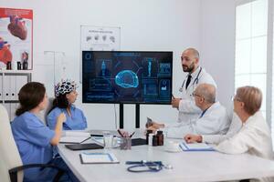 Hospital medical team doing brain activity research using headset with sensors monitoring radiography expertise. Physician doctors analyzing sickness treatment working in conference meeting room photo
