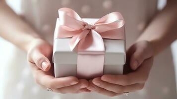 AI generated Hands holding a gift wrapped in pink paper with a satin ribbon, symbolizing thoughtfulness and care in a delicate, feminine presentation photo