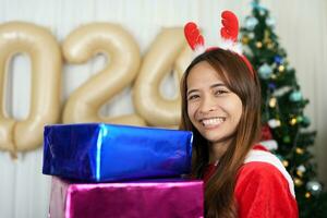 alegre Navidad 2024 concepto asiático mujer son contento y Encantado a recibir Navidad regalos. foto