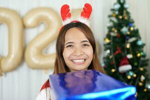 Merry Christmas 2024 concept Asian women are happy and delighted to receive Christmas gifts. photo