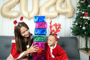 alegre Navidad 2024 concepto chico recibe un regalo desde su madre a Navidad foto