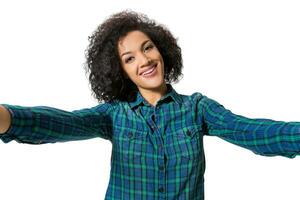 Young beautiful African American woman makes self against the white background in studio photo