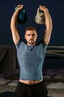 Muscular man working with weights at outdoor photo