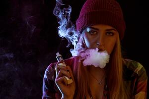 young woman smoking electronic cigarette photo