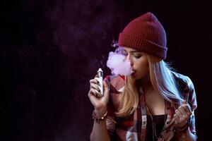 young woman smoking electronic cigarette photo