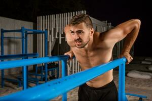 Strong young athlete is engaged in on sports field. photo