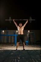 Man makes exercises with barbell photo