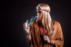 Young woman in the Boho style blowing smoke photo