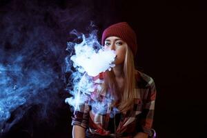 young woman smoking electronic cigarette photo