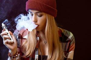 young woman smoking electronic cigarette photo