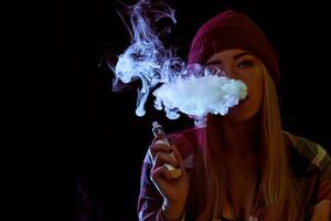 young woman smoking electronic cigarette photo