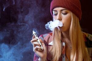 young woman smoking electronic cigarette photo