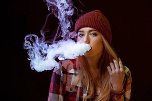 young woman smoking electronic cigarette photo