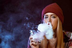 young woman smoking electronic cigarette photo