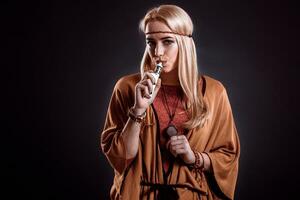joven mujer en el boho estilo soplo fumar foto