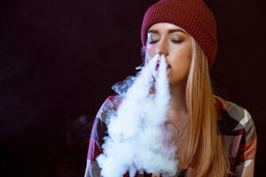 young woman smoking electronic cigarette photo