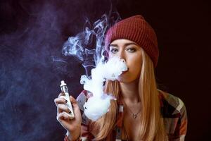 young woman smoking electronic cigarette photo