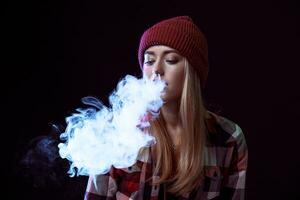 young woman smoking electronic cigarette photo