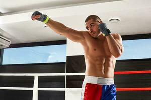 Boxer en azul guantes calentamiento arriba en el gimnasio foto