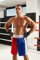 Boxer en azul guantes calentamiento arriba en el gimnasio foto