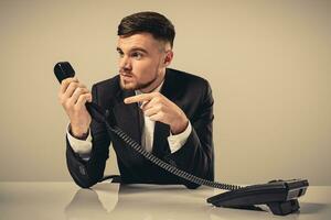 Portrait of attractive businessman holding telephone in his hand photo