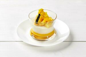 Creamy Panna cotta with mango and vanilla in glass photo