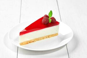 Slice of Philadelphia cheesecake with raspberry jelly and berries photo