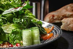 ensalada con verduras, pepino, caqui, granada y rallado nueces foto