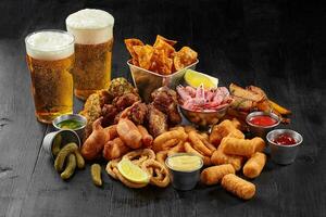 Beer set of savory snacks with sauces, pickles and lemon photo