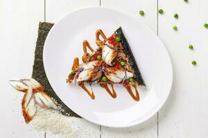 Pizza sushi with eel, red tobiko, shiitake and unagi sauce photo