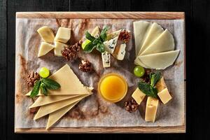 Sliced sulguni, mozzarella, dor blue and semi firm cheeses on wooden board photo