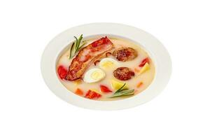 Polish soup zur with bacon, sausages and egg isolated on white photo