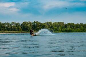 hombre montando wakeboard en calma río en verano día foto