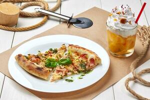 Pizza with bacon, leek, basil with lemonade topped with whipped cream photo