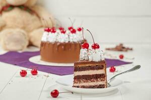 Slice of chocolate sponge cake with custard and cherries photo